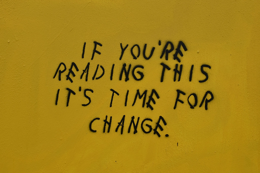 Schwarzer Text auf gelber Wand: If you're reading this it's time for change. Anspielung auf das Jugendwort, das sich jedes Jahr ändert. Foto von hayleigh b auf Unsplash