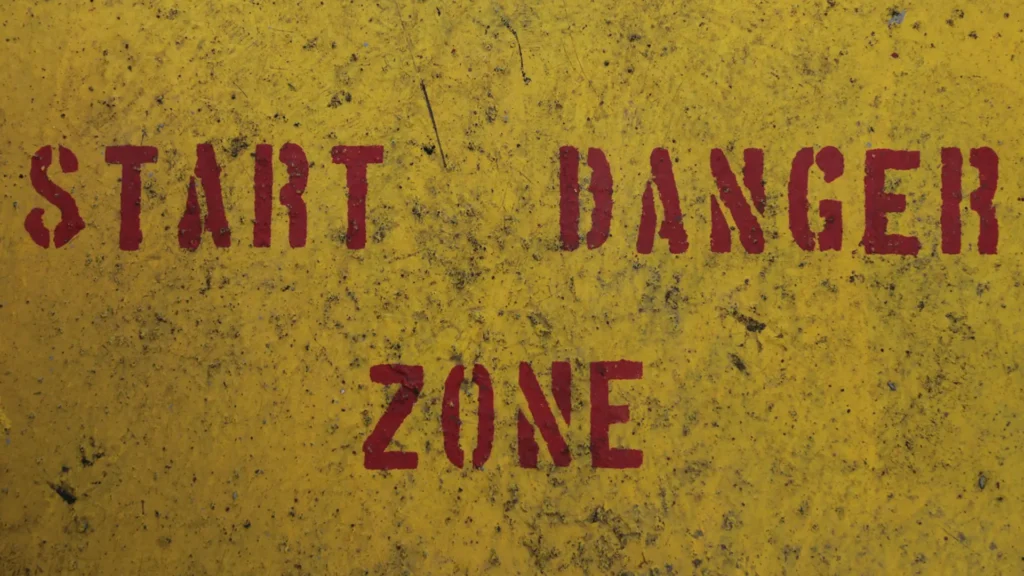 Buchverbote USA: Warnschild mit der Aufschrift „Start Danger Zone“ – Symbolbild für Zensur, Kulturkampf und die politische Brisanz rund um