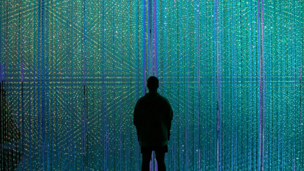 Silhouette eines Menschen vor einer leuchtenden digitalen Wand – Metapher für digitale Unabhängigkeit im digitalen Raum und den Weg in eine unabhängige, technologische Zukunft.