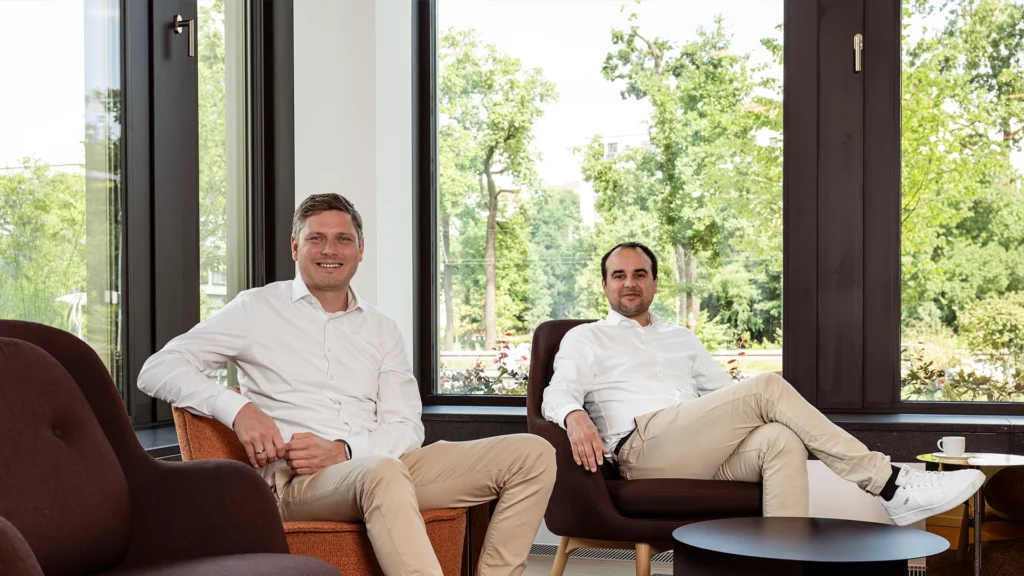 Christian Selzer und Sebastian Schüler sitzen im Büro der Sparkasse und erklären, wie sie Kund:innen helfen, ihre Gründung zu finanzieren