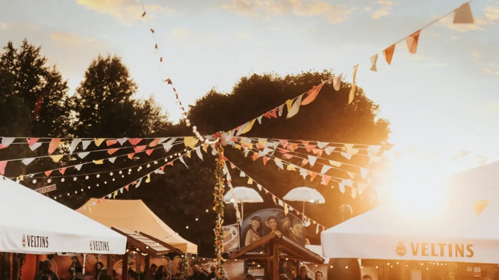 Wimpelketten und Festzelte bei Sonnenuntergang, typische Stimmung für Sommer-Festivals in Deutschland